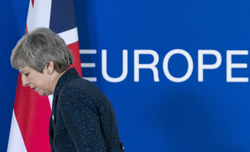 Theresa May in front of UK and European flags